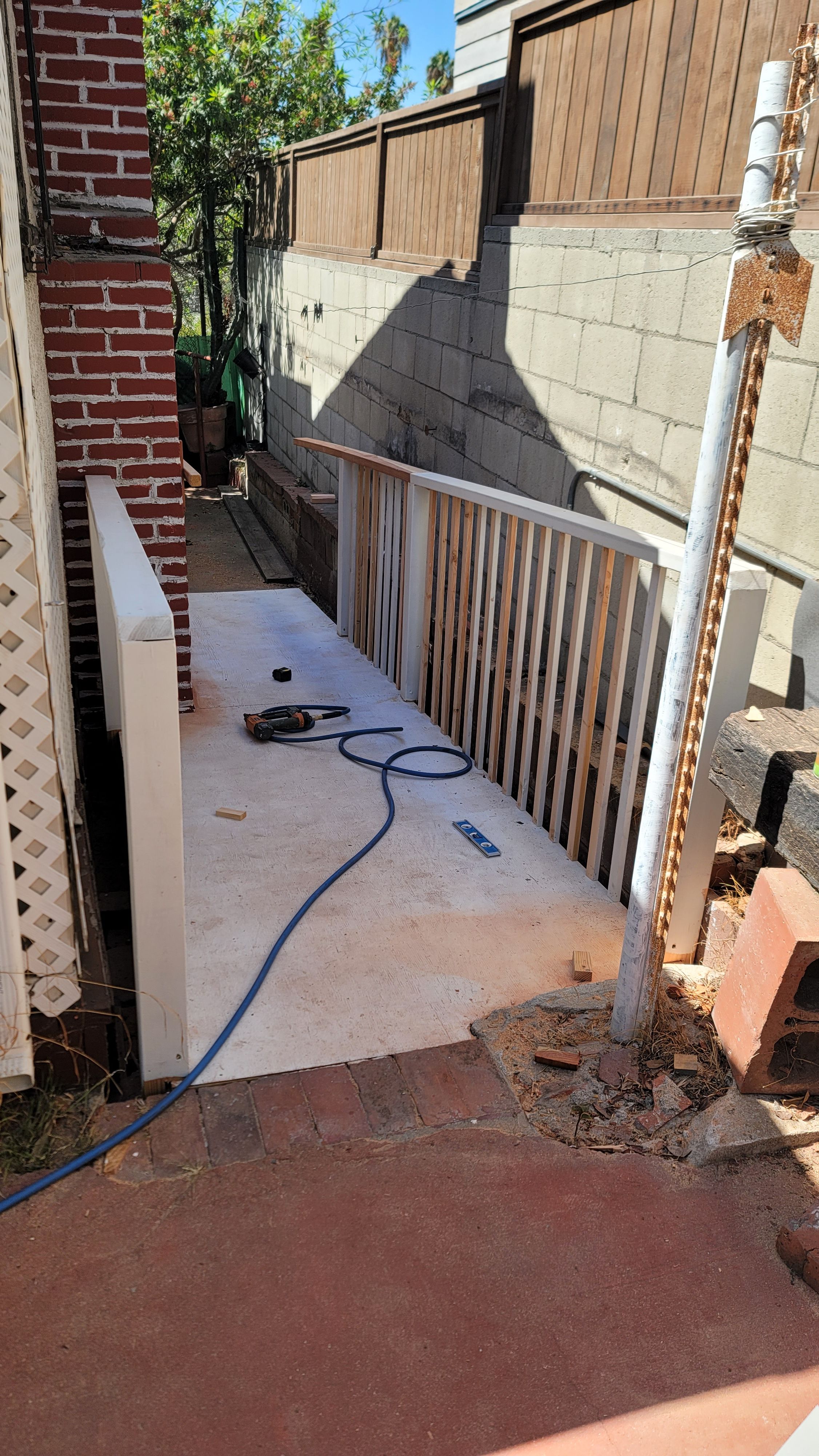 Concrete side walkway alongside a block wall and railing