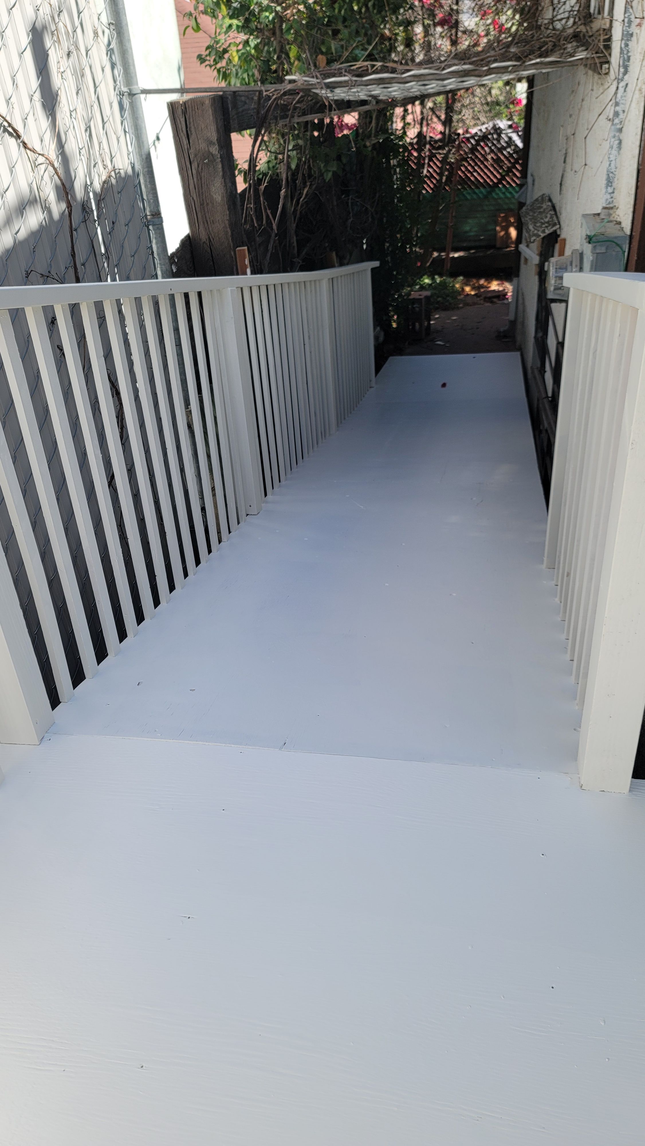 Coated walkway with white railings and dark metal balusters