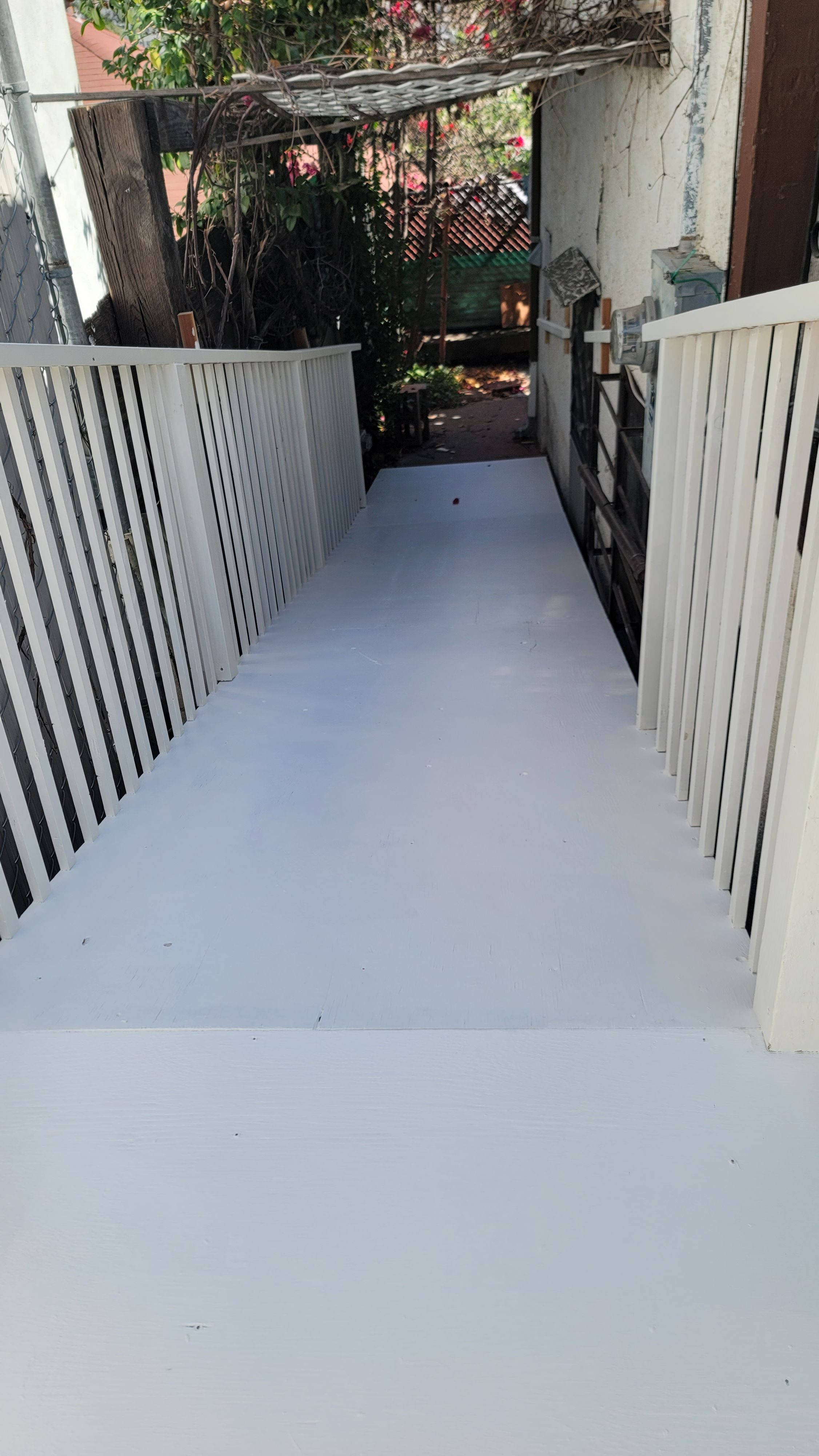 Smooth coated concrete walkway running between white railings