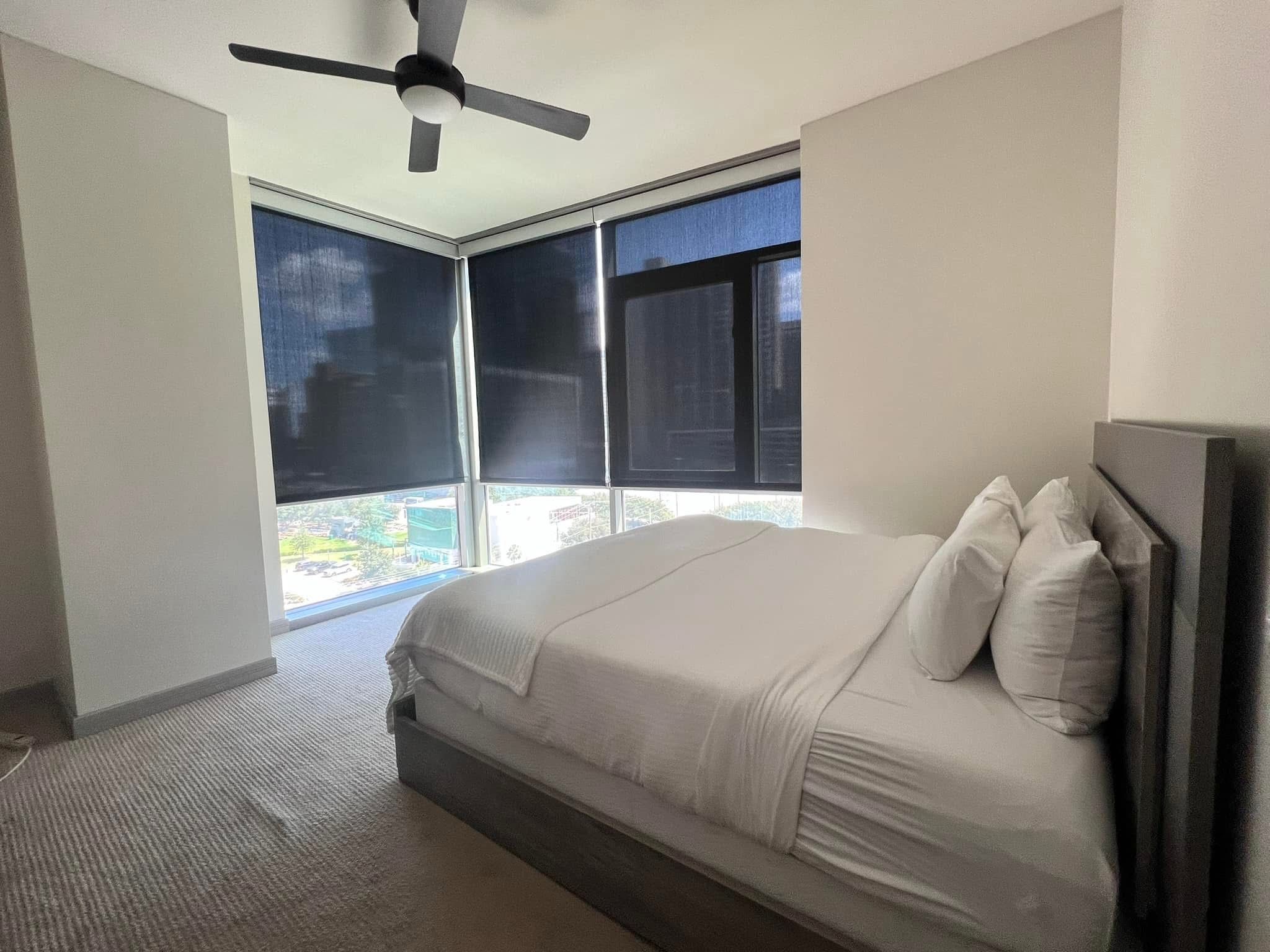 Carpeted bedroom prepared with fresh bedding and folded towels