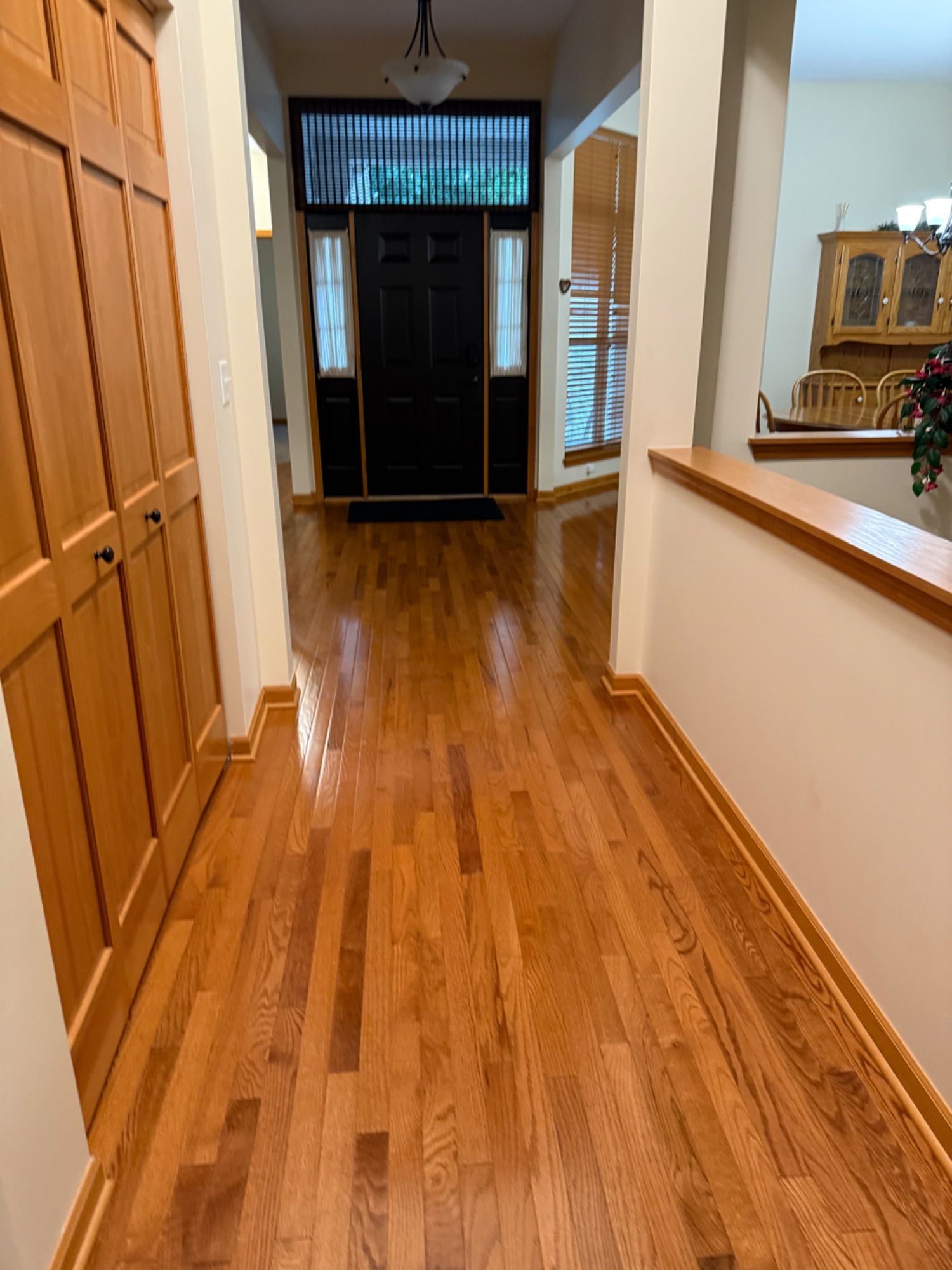 Freshly cleaned hardwood hallway leading into a residential kitchen