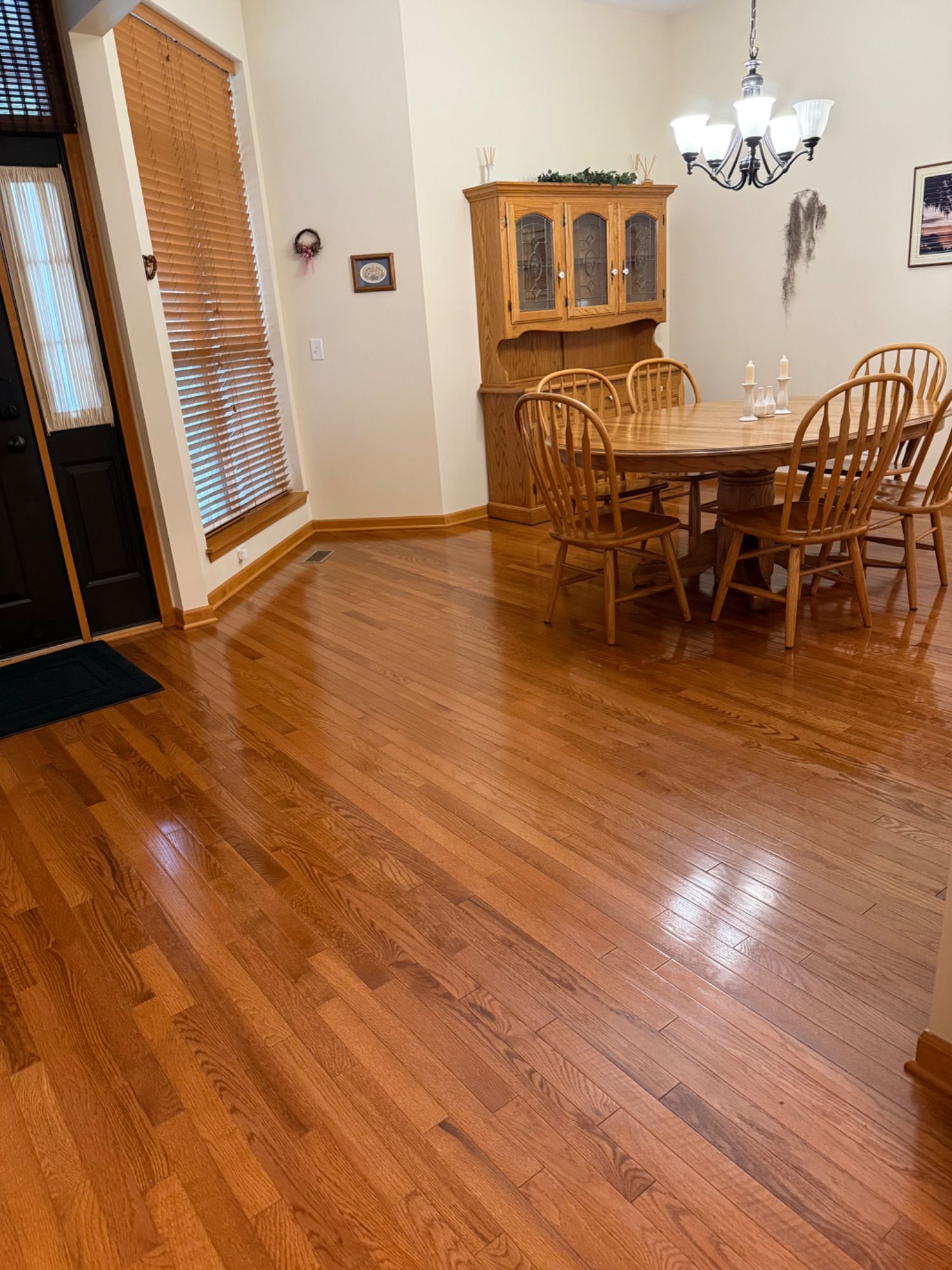Clean dining area with polished hardwood floor and arranged furniture
