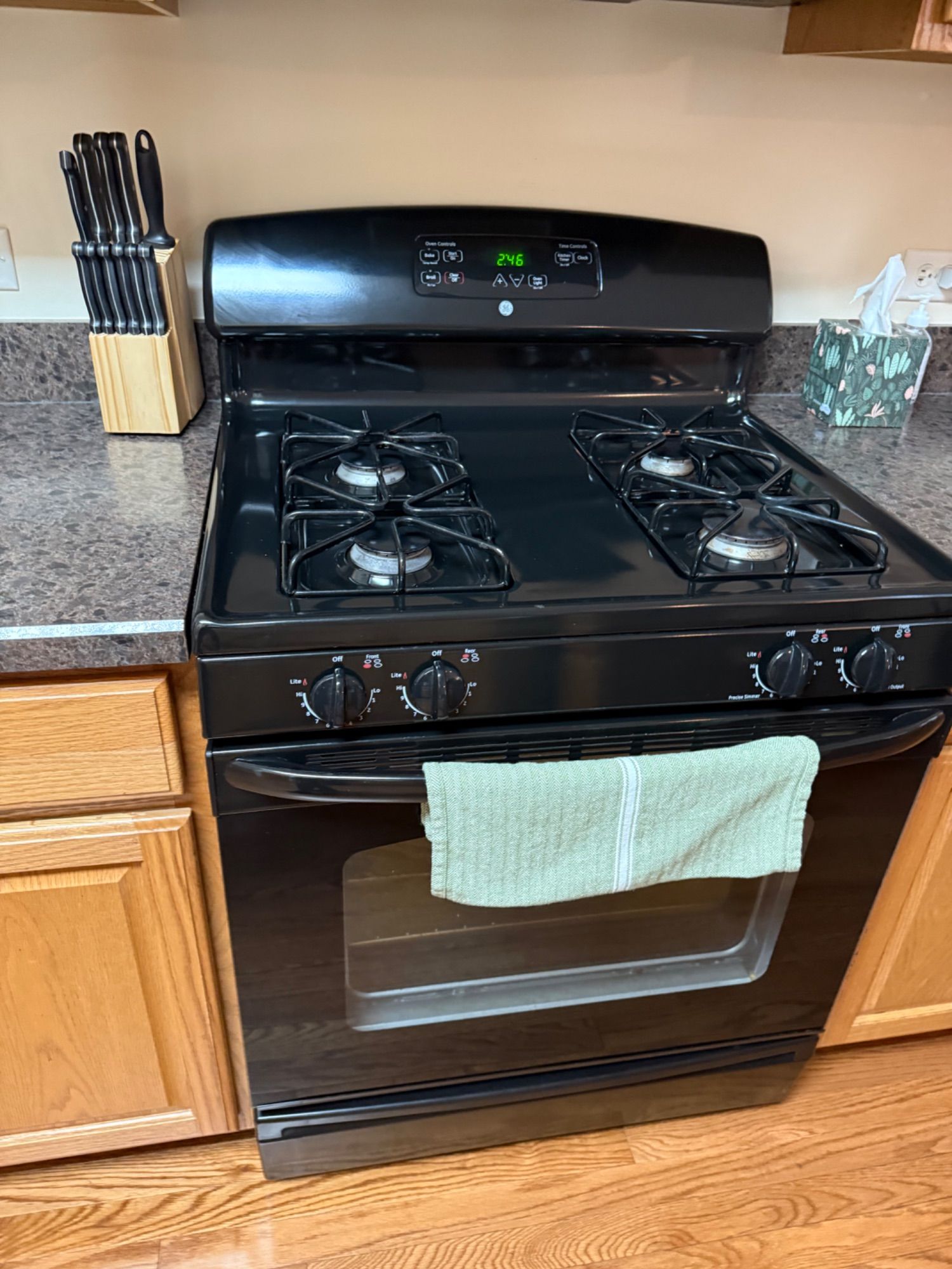 Freshly cleaned black range and stovetop in a residential kitchen