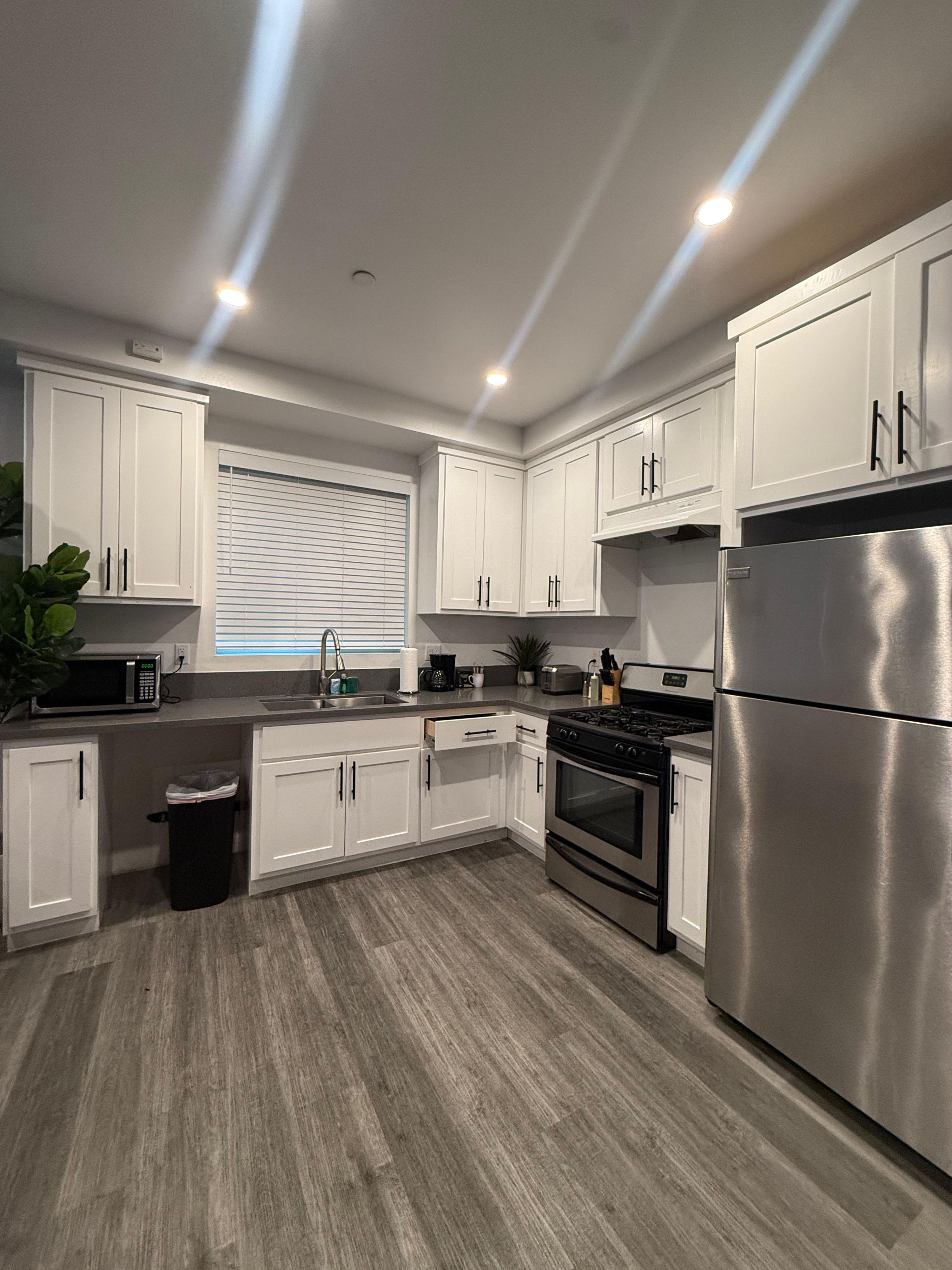 Kitchen with white cabinets, stainless refrigerator and gas range