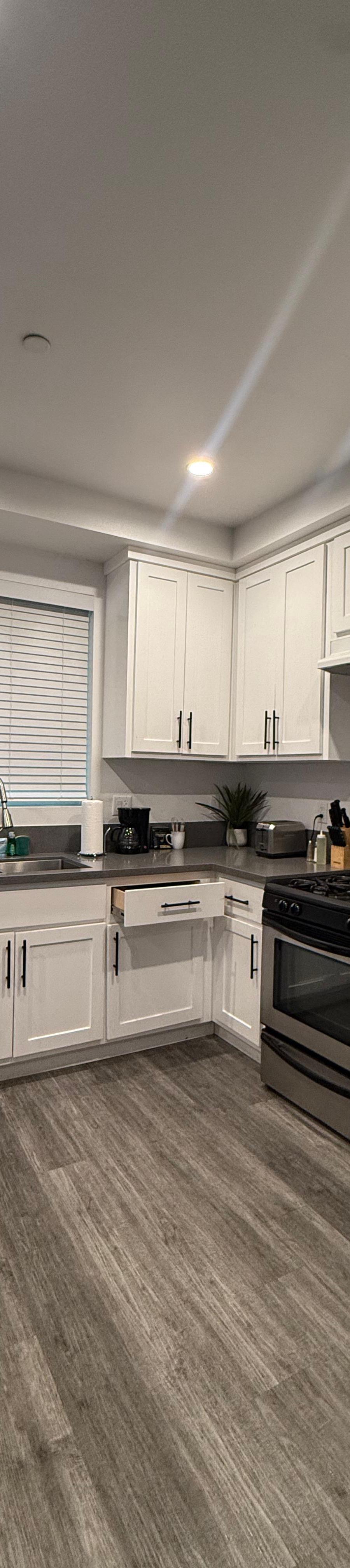 Kitchen with white cabinets, stainless refrigerator and gas range