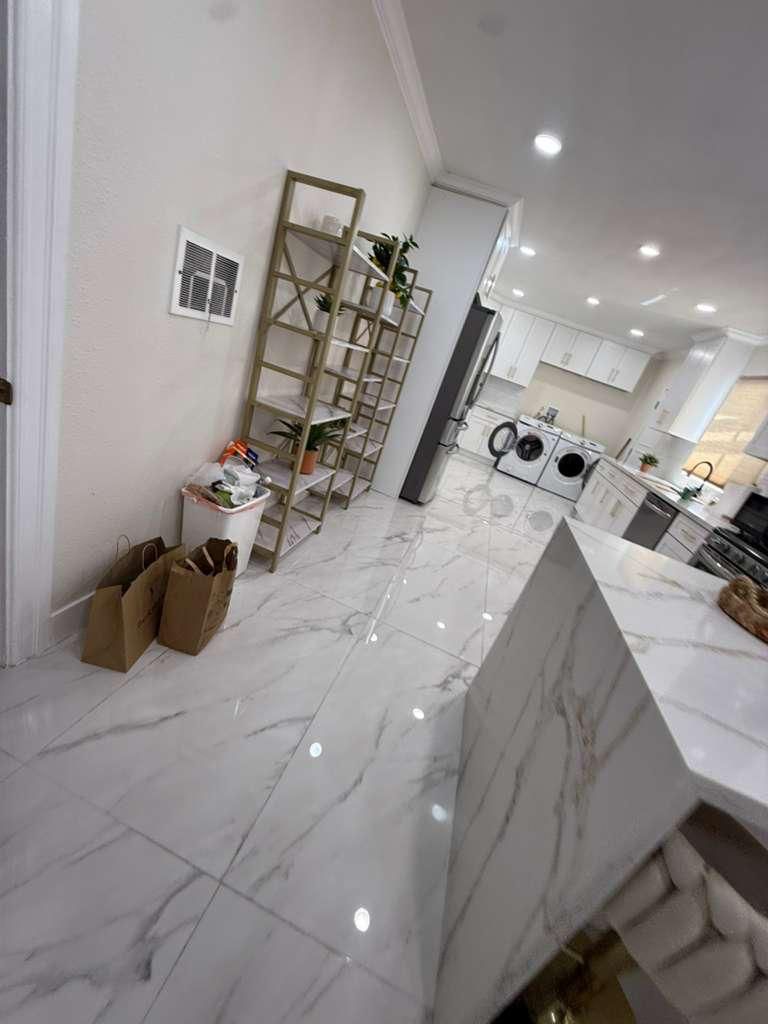 Hallway with marble tile floor leading to a laundry area