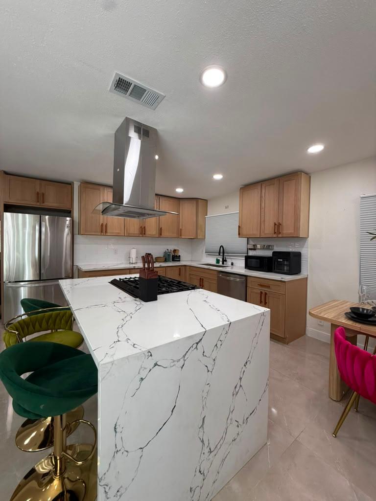 Polished marble kitchen island and spotless cabinets in a Los Angeles rental after a J.Jhany cleaning
