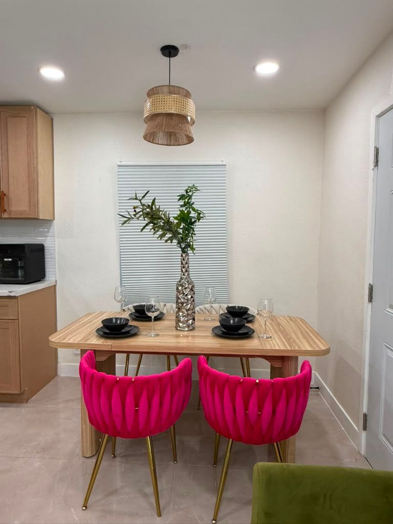 Dining table set with plates under a woven pendant light