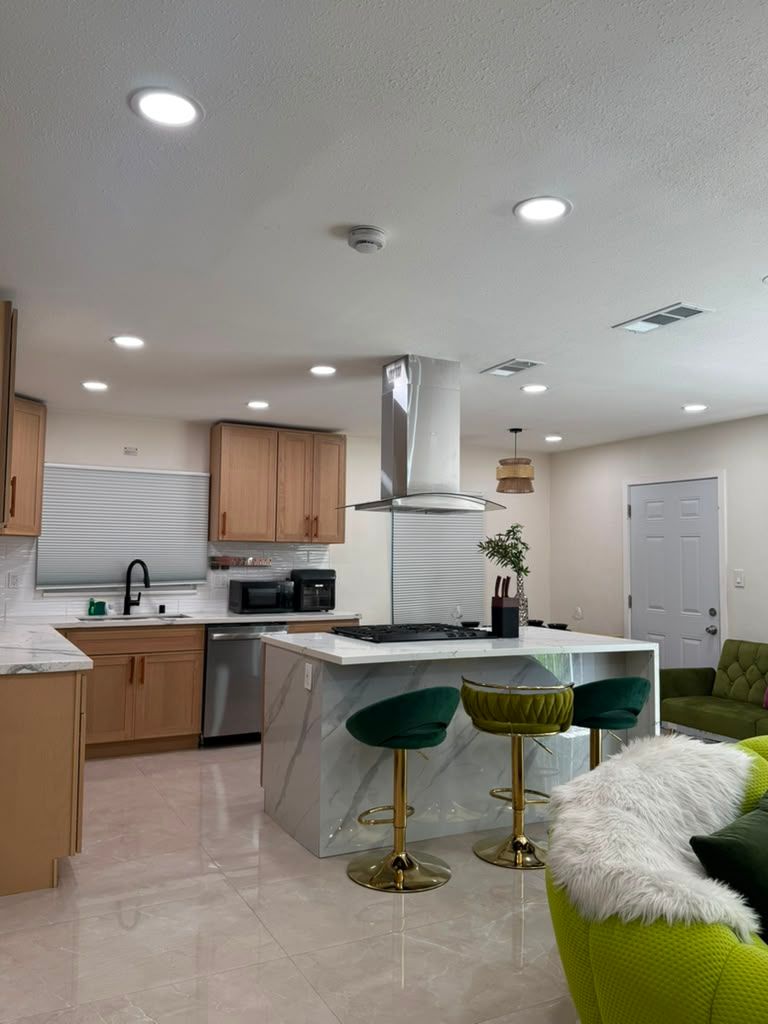 Open kitchen and living area with tile floor and marble island