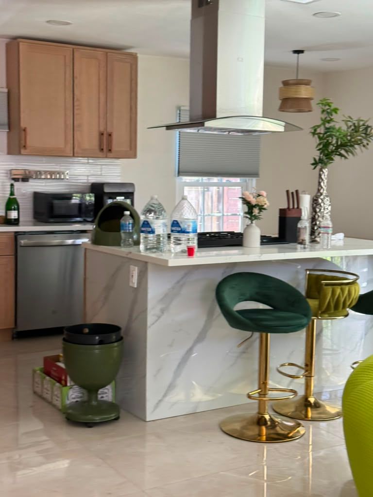 Kitchen island with marble counter and green bar stools