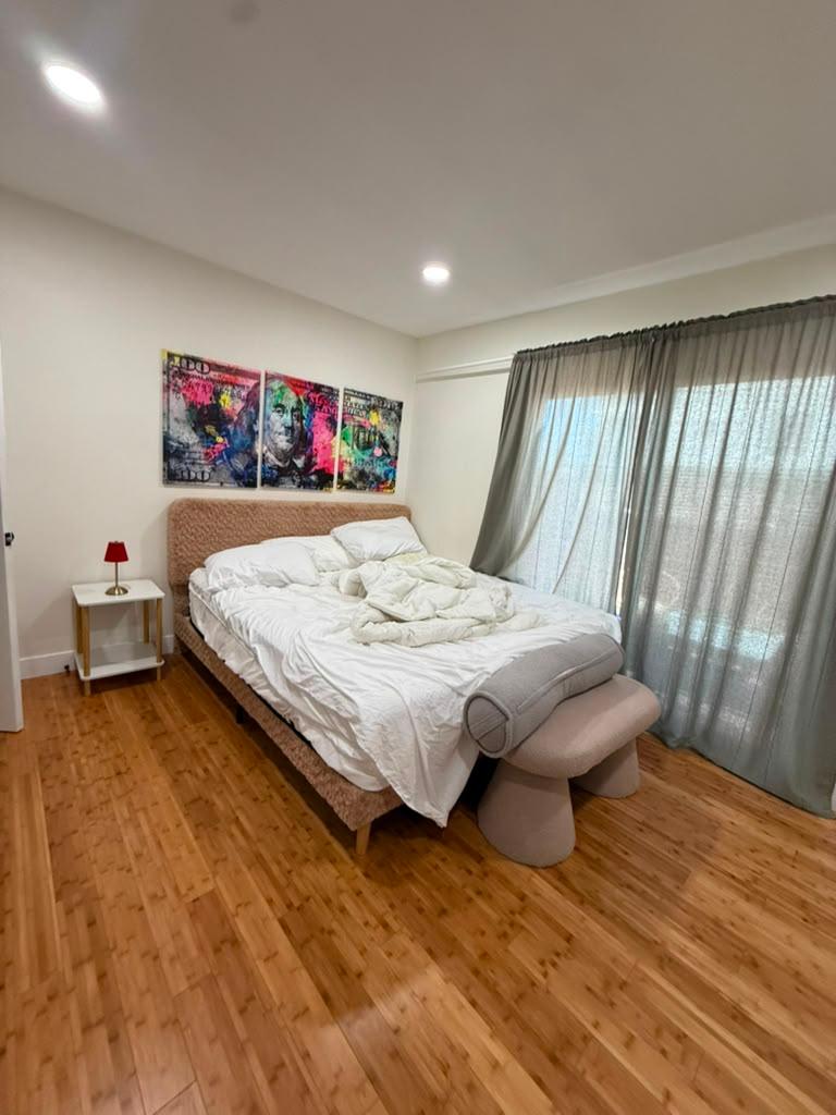 Bedroom before cleaning, with an unmade bed and colorful wall art