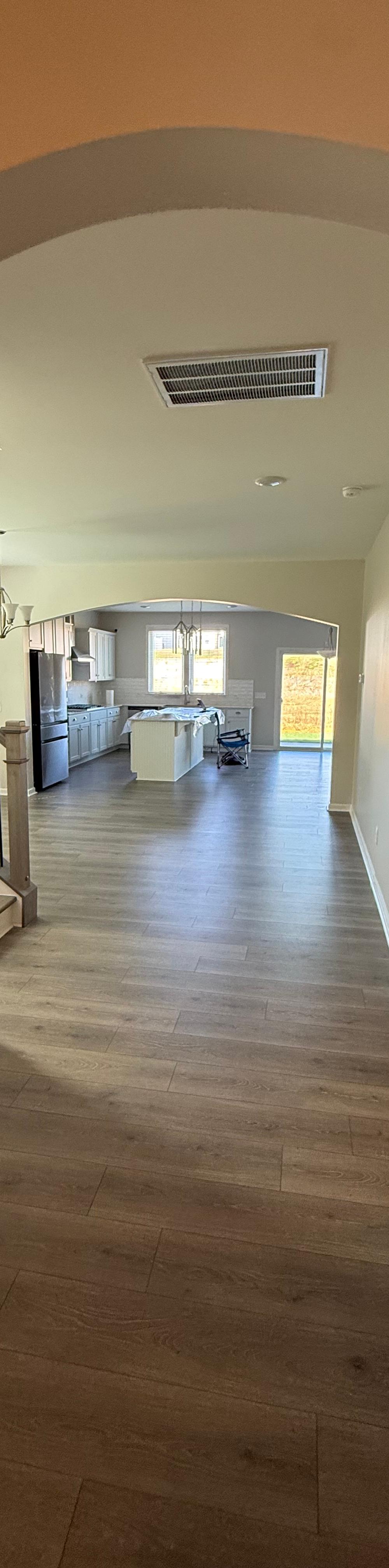 Arched hallway with freshly painted walls and new vinyl plank flooring by JD Painting