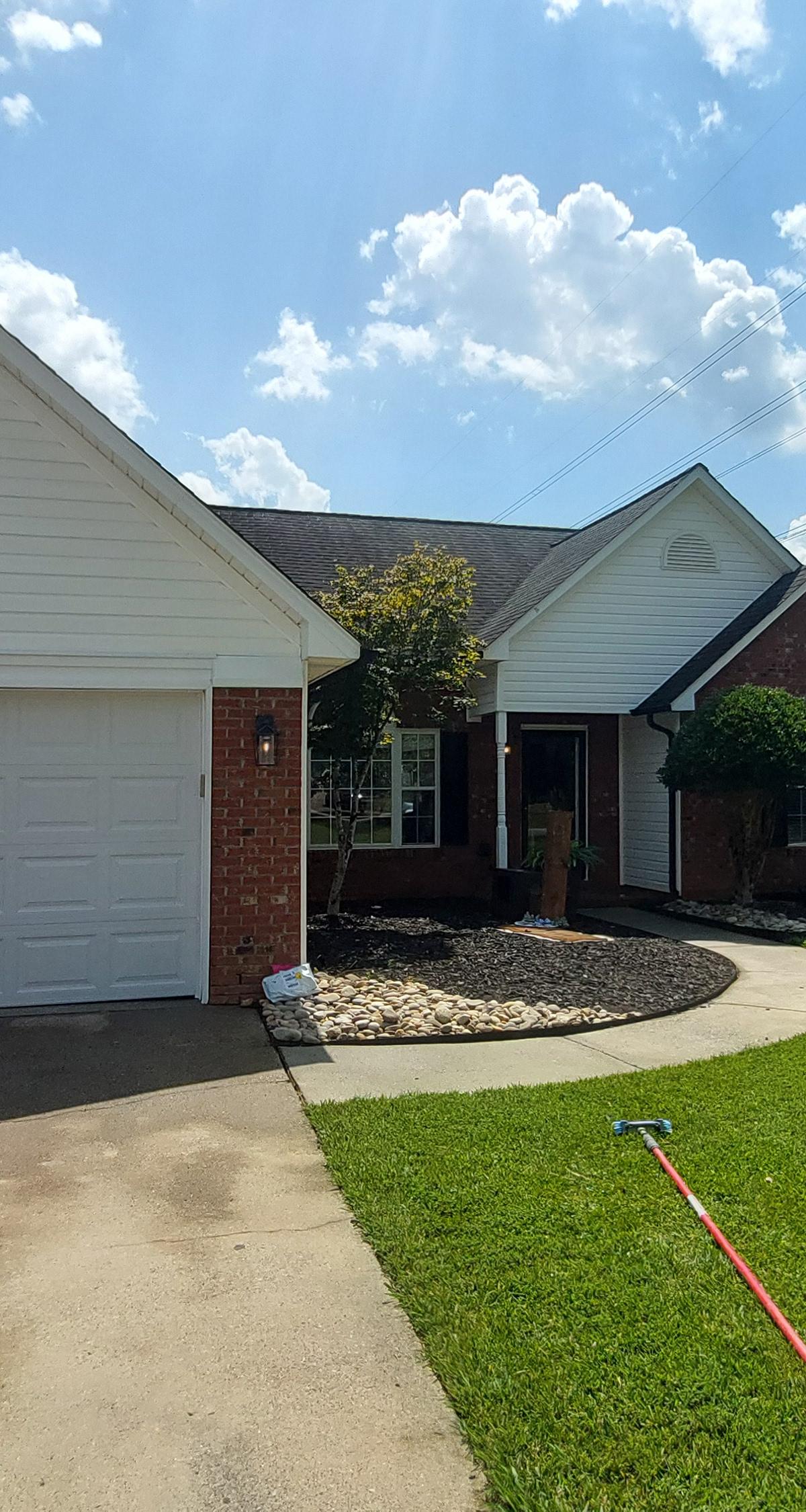Brick home with a freshly cleaned driveway and walkway