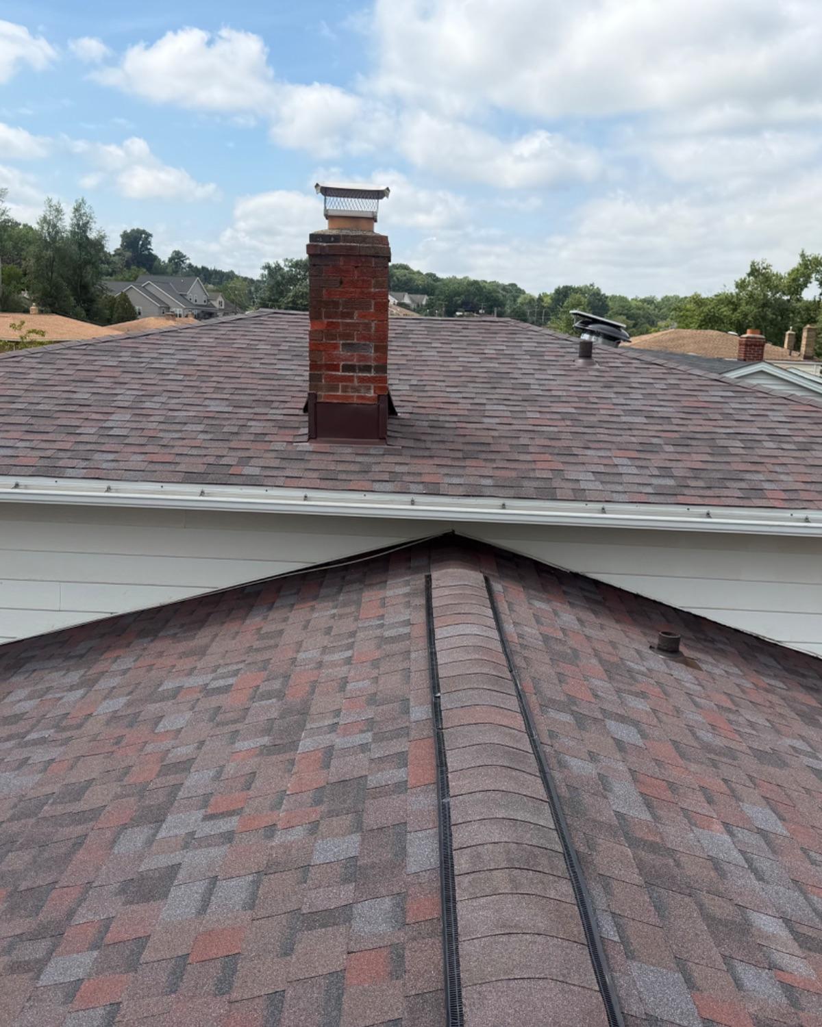 Brick chimney and new shingles on a home roofed by L&J Roofing