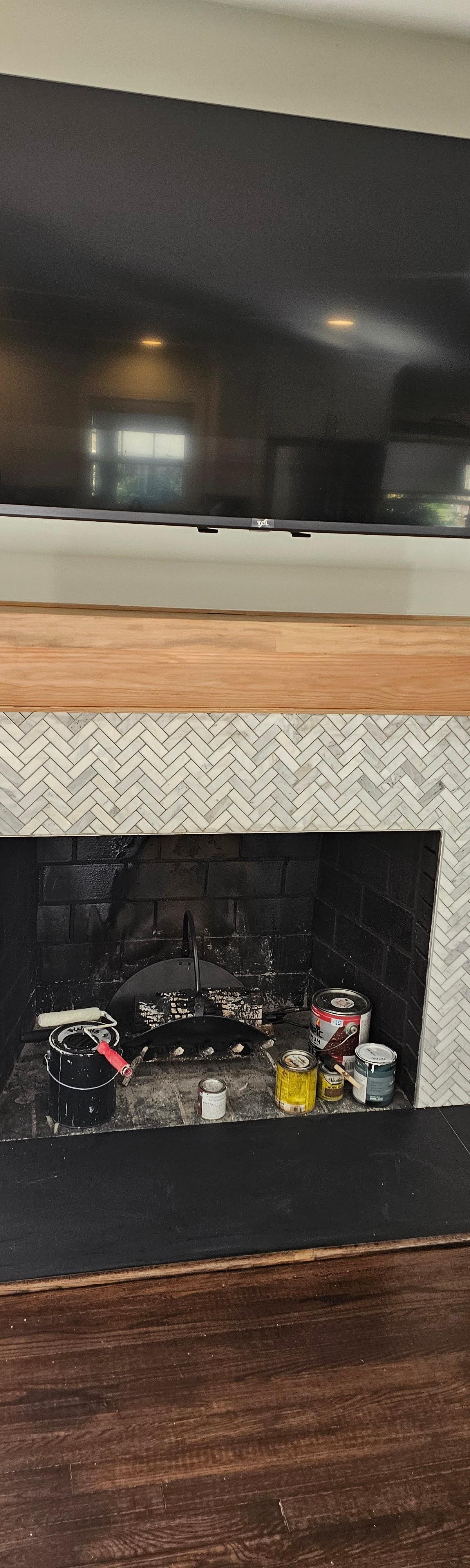 Custom wood fireplace mantel with herringbone tile surround built by New Generation Home Improvement