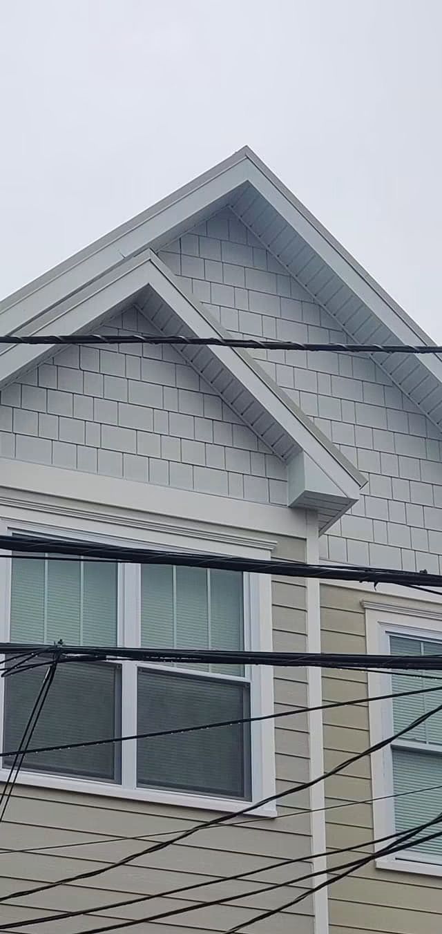 Twin gables with shake-style siding and crisp white roofline trim — NYE General Construction