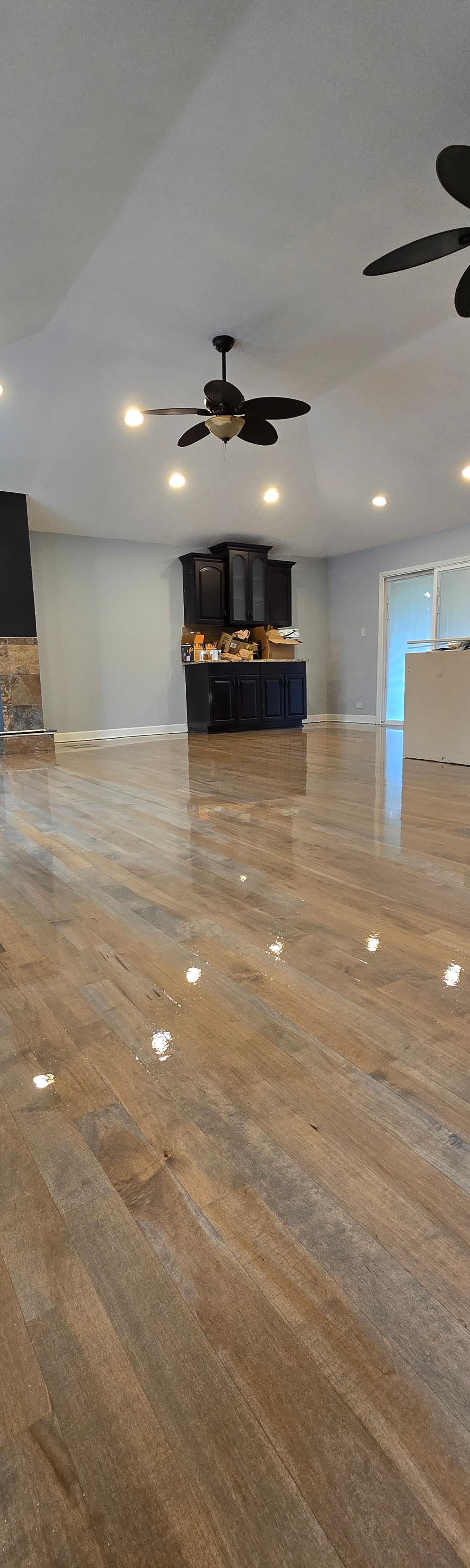 Freshly refinished high-gloss hardwood floor in an open-plan home by One Star Flooring