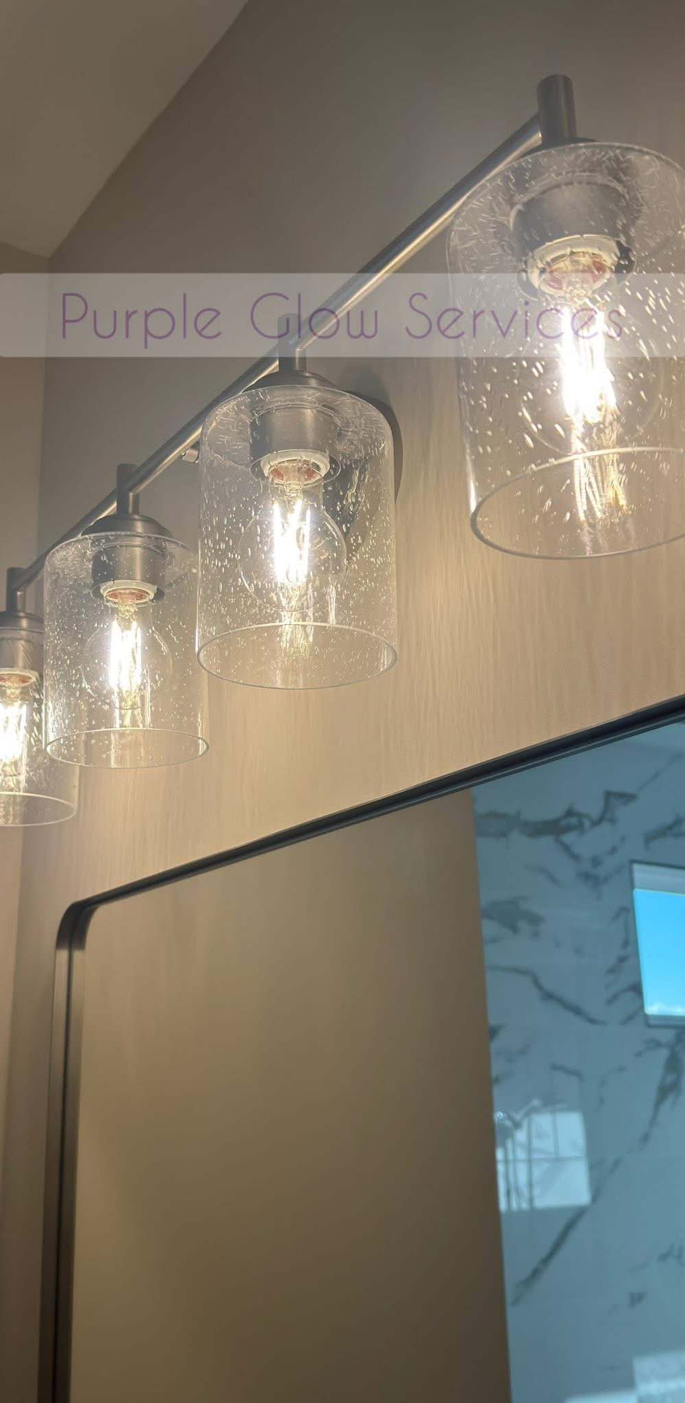 Bathroom vanity light bar with clear glass shades cleaned above a spotless mirror in Middle Tennessee