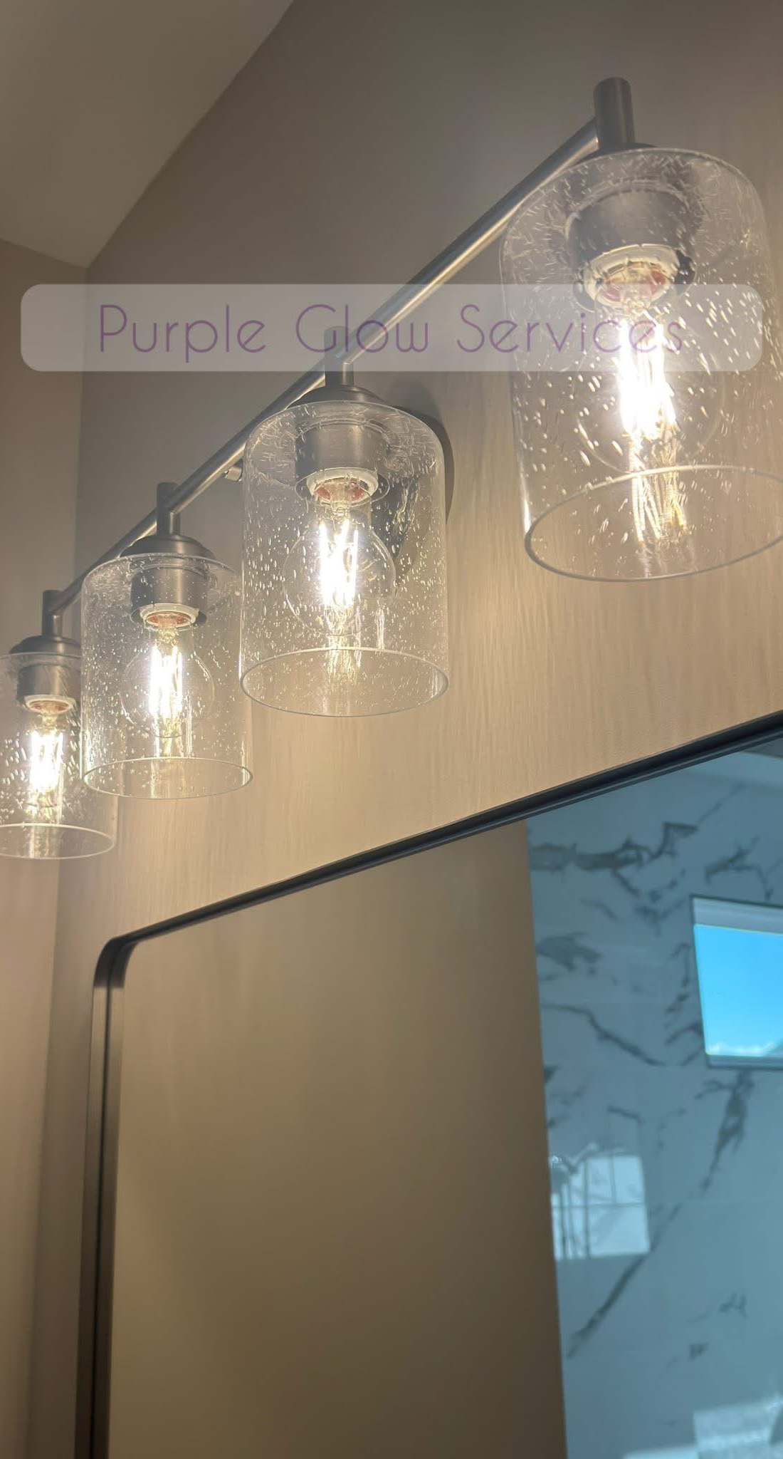 Bathroom vanity light bar with clear glass shades cleaned above a spotless mirror in Middle Tennessee