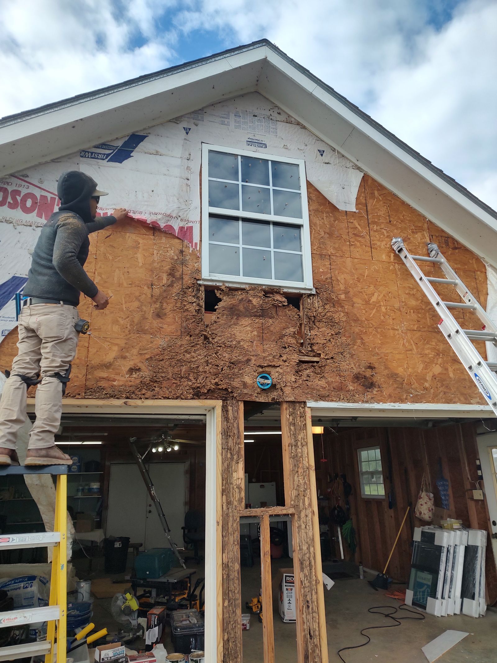 Round Top Construction crew replacing siding on a two-story farmhouse