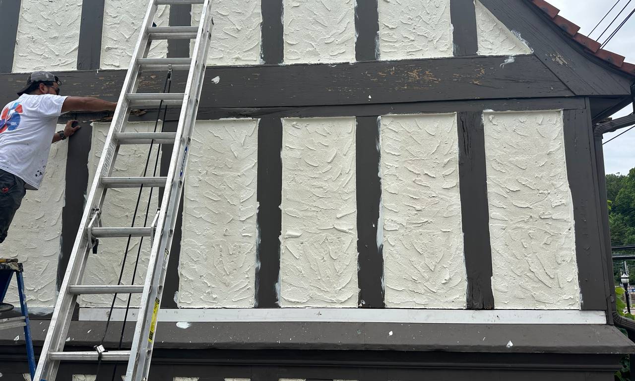 Roypainting Service LLC painter on a ladder repainting a home exterior in Chester County, Pennsylvania