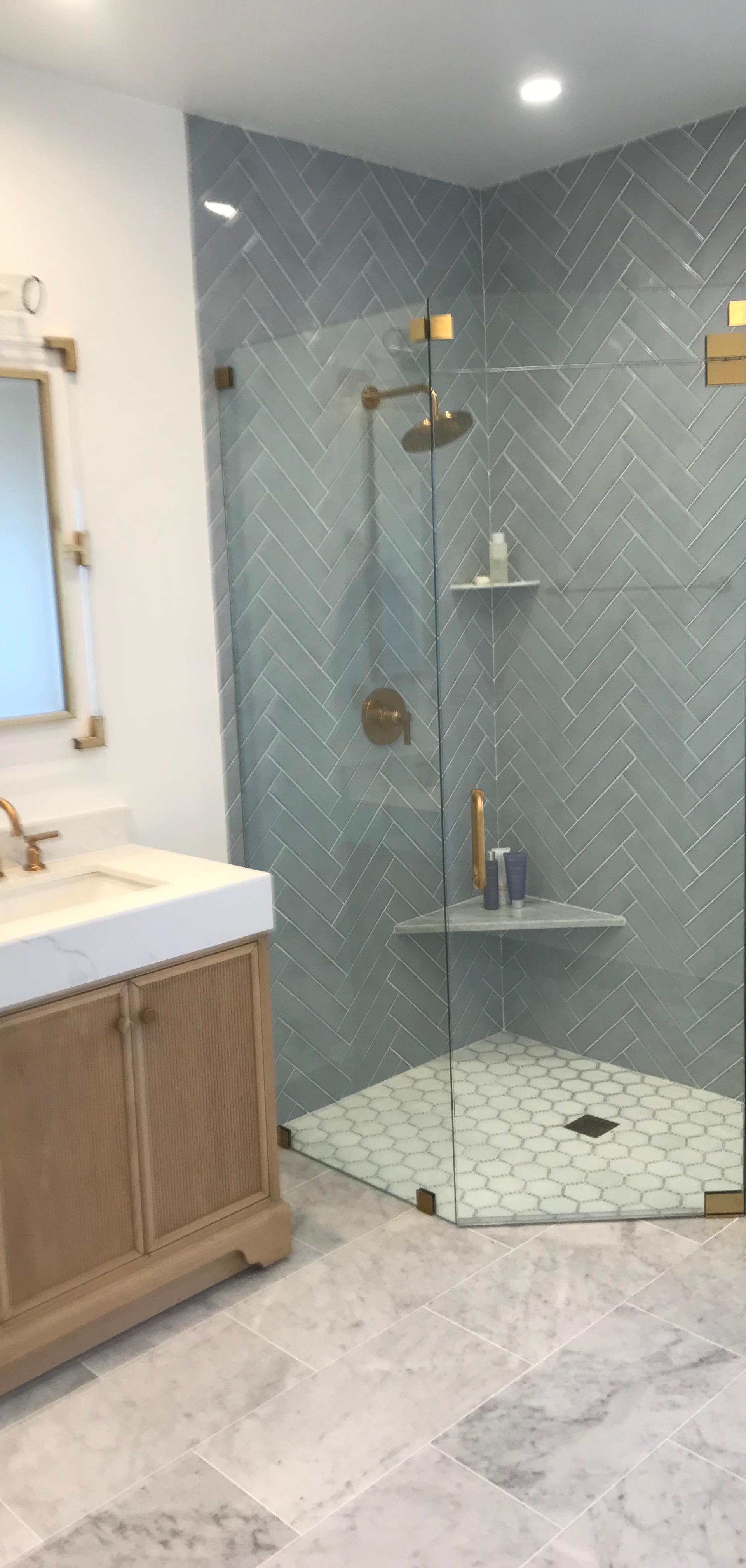 Finished bathroom remodel by Silva Remodeling Corp with oak vanity and frameless glass corner shower