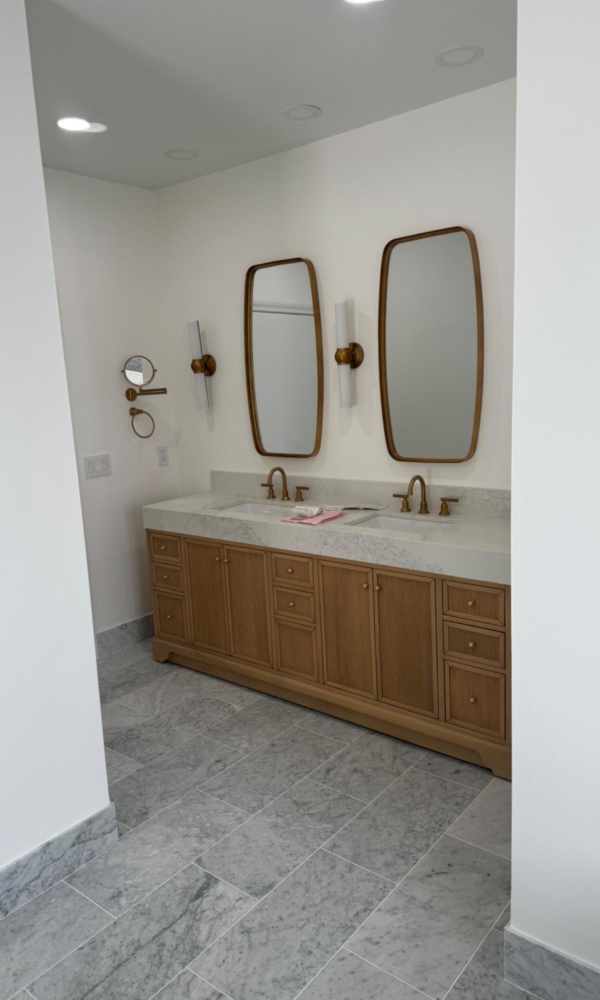 Double oak vanity with marble top and brass mirrors installed by Silva Remodeling Corp