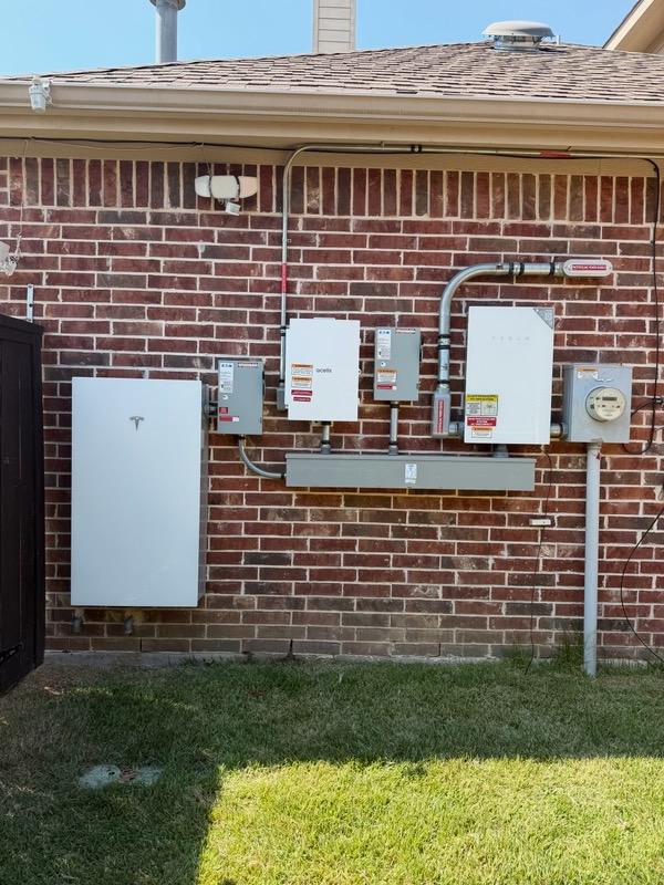 Tesla Powerwall, gateway, and solar disconnects on a brick home serviced by Solargy Solutions