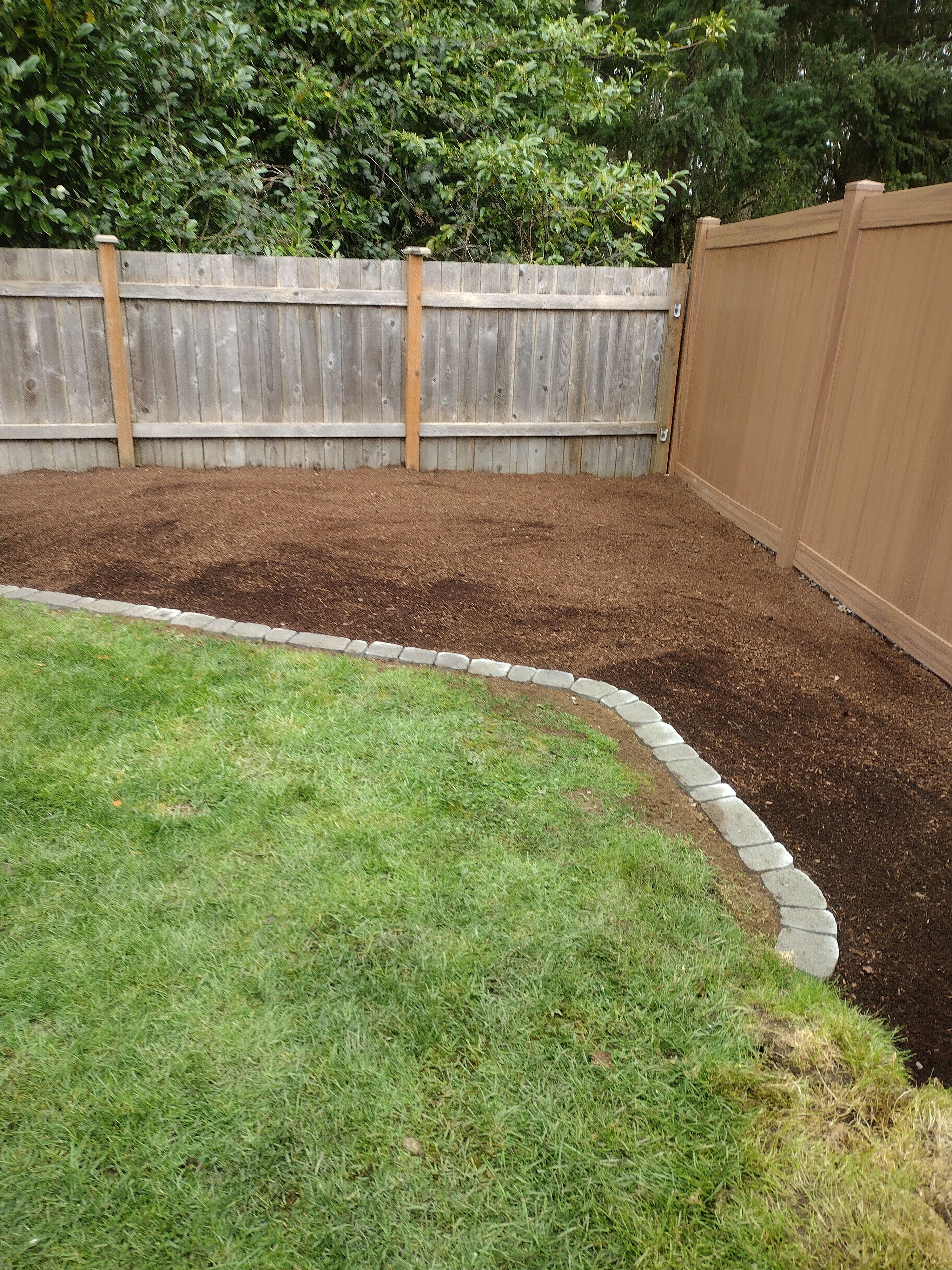 Finished garden bed with stone border and fresh topsoil