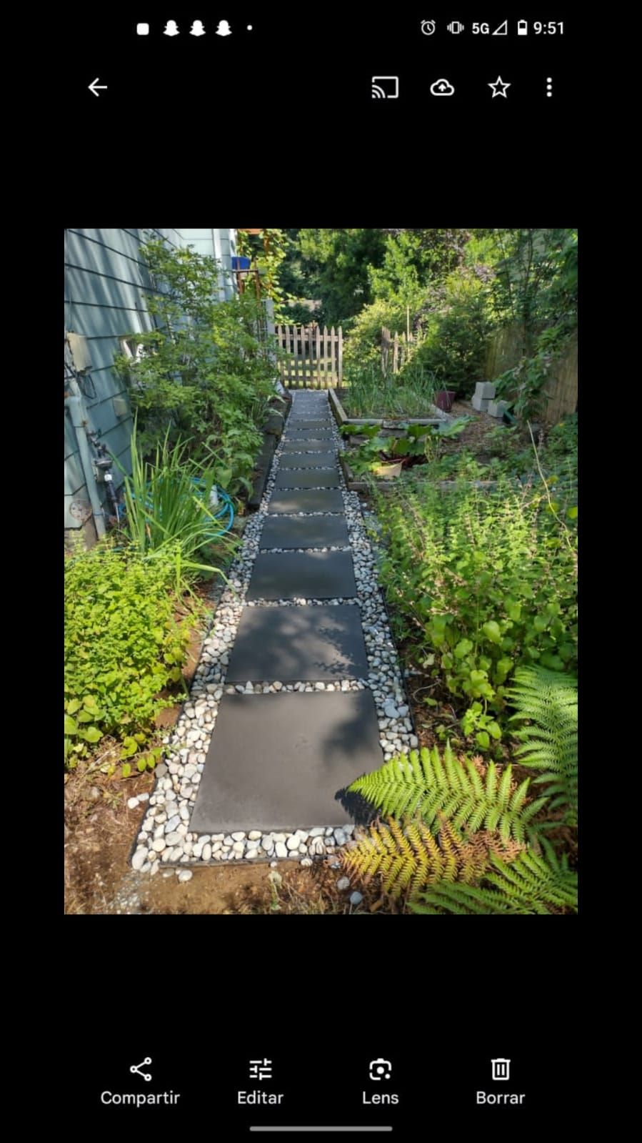 Stone paver walkway set in river rock through a shaded garden