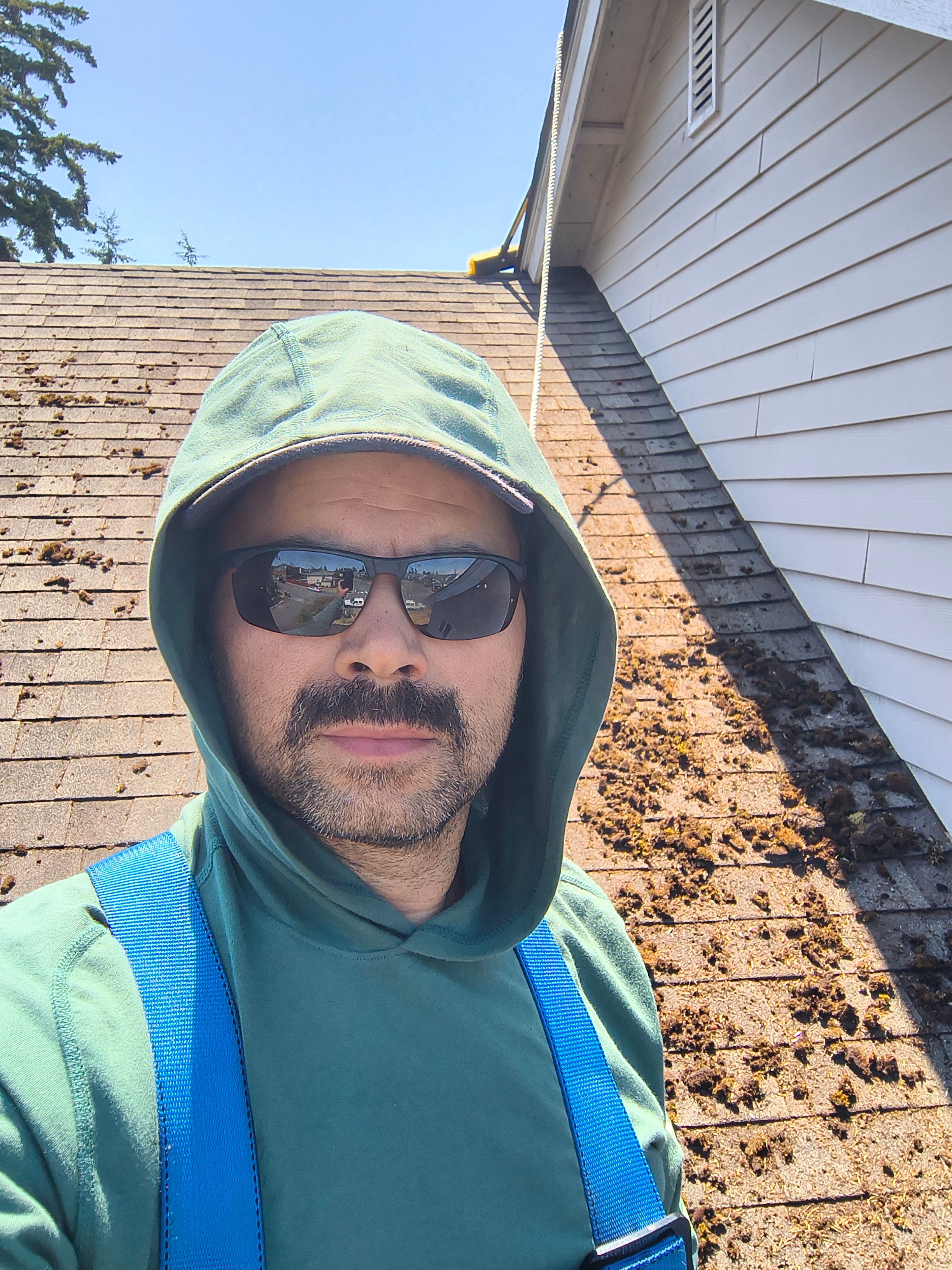 Superlux crew clearing moss from a roof and gutter line