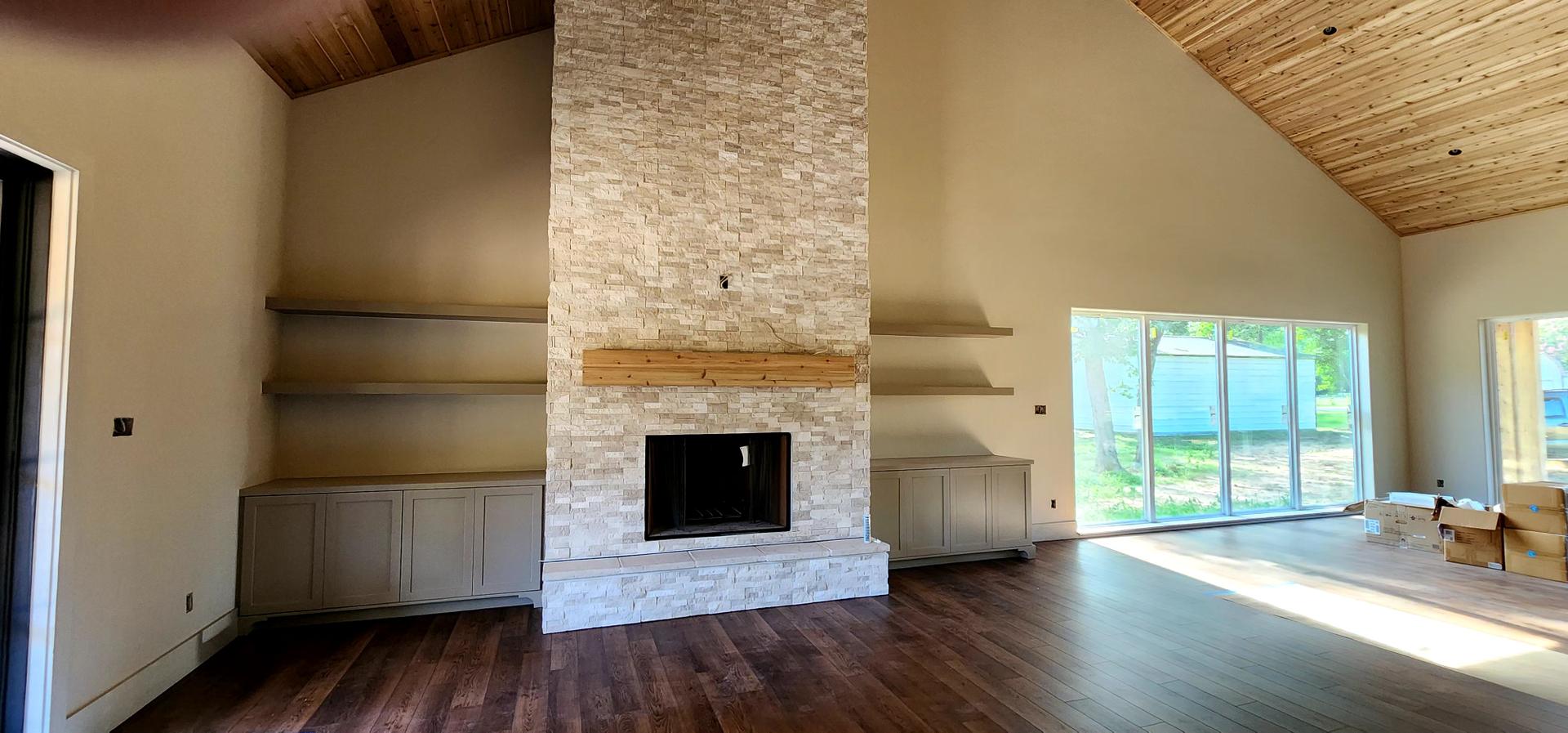 Great room with stacked-stone fireplace and new hardwood floors, renovated by Tejas Renovations Custom Homes