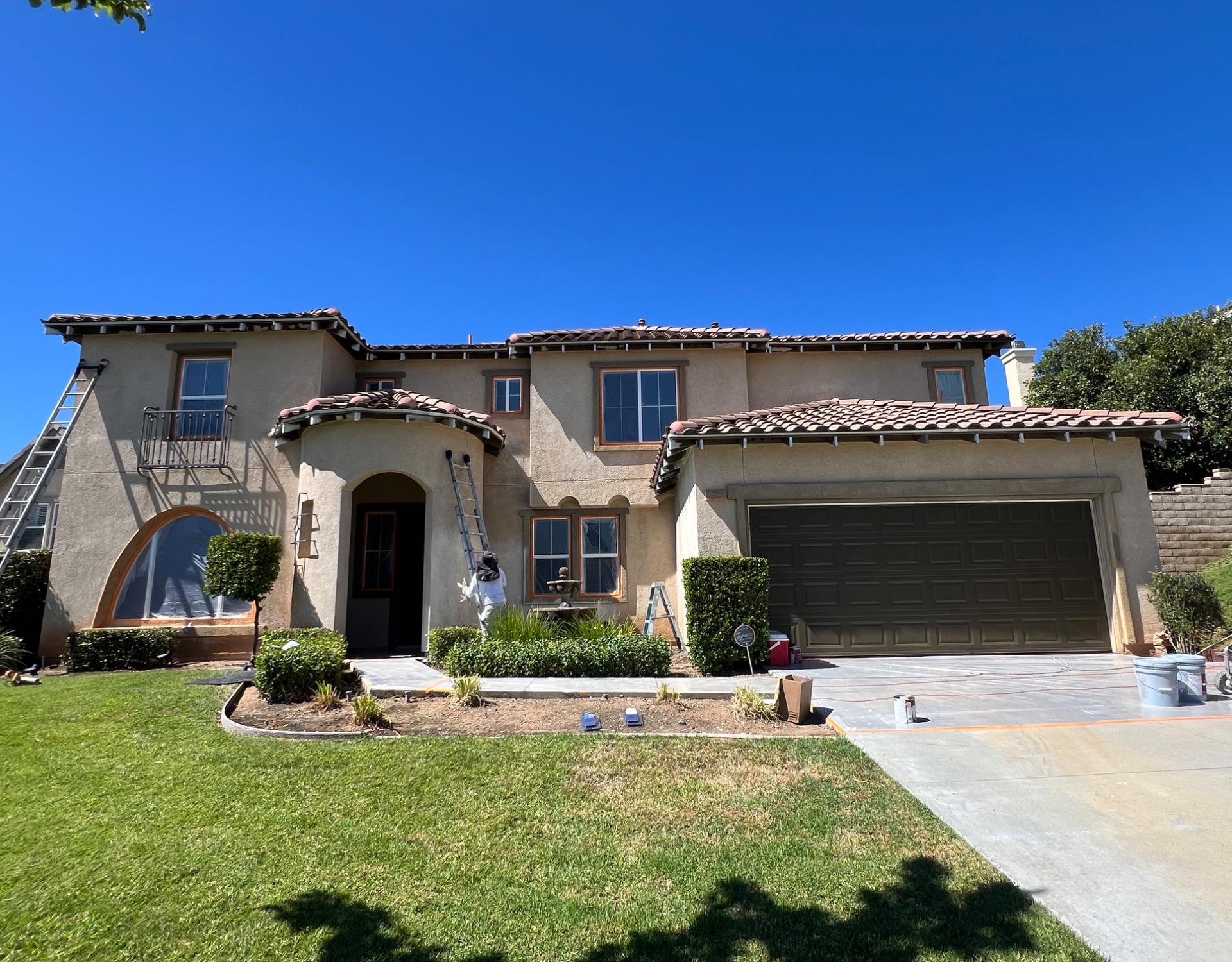 The Painting Monkeys crew repainting a two-story stucco home in Orange County