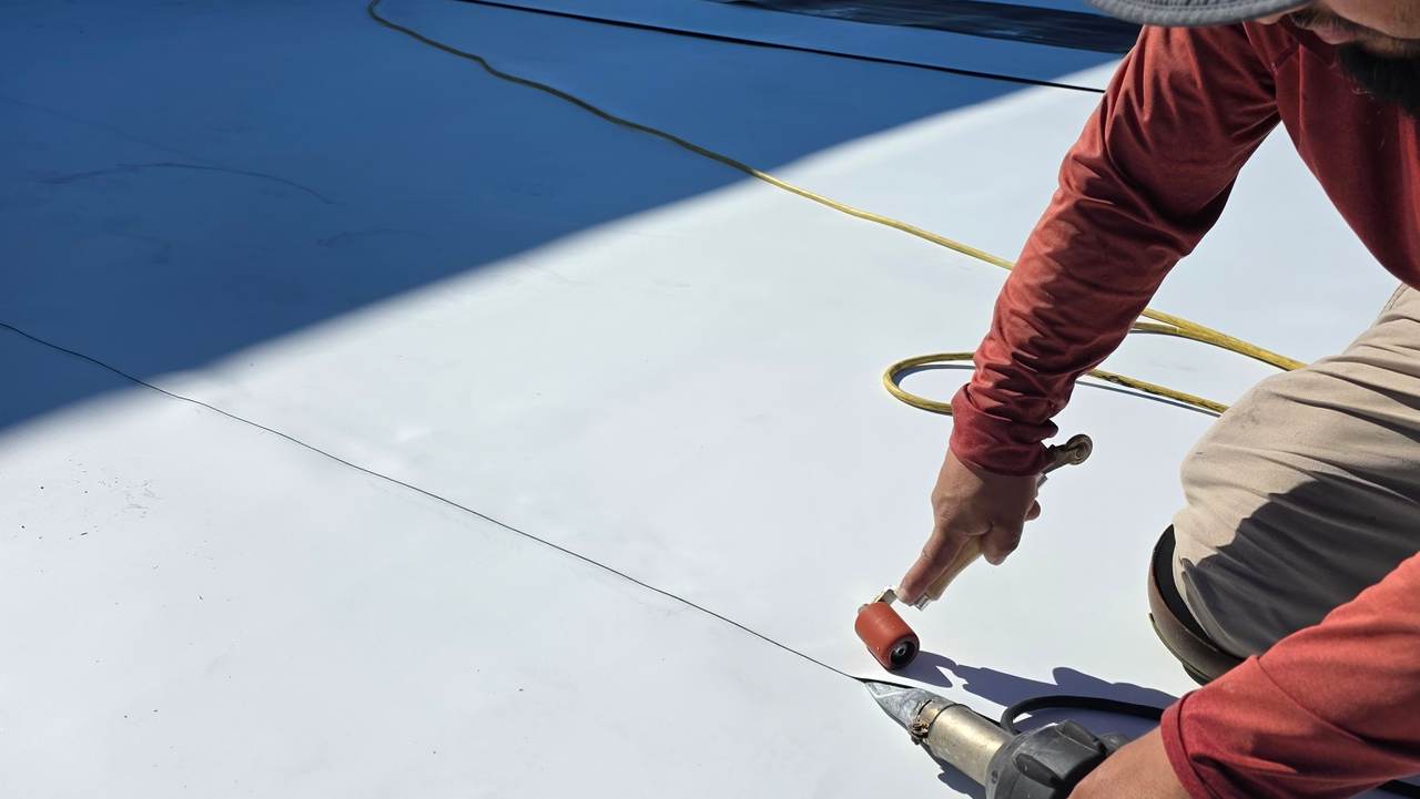 VZR Roof Services crew heat-welding a TPO commercial roof membrane