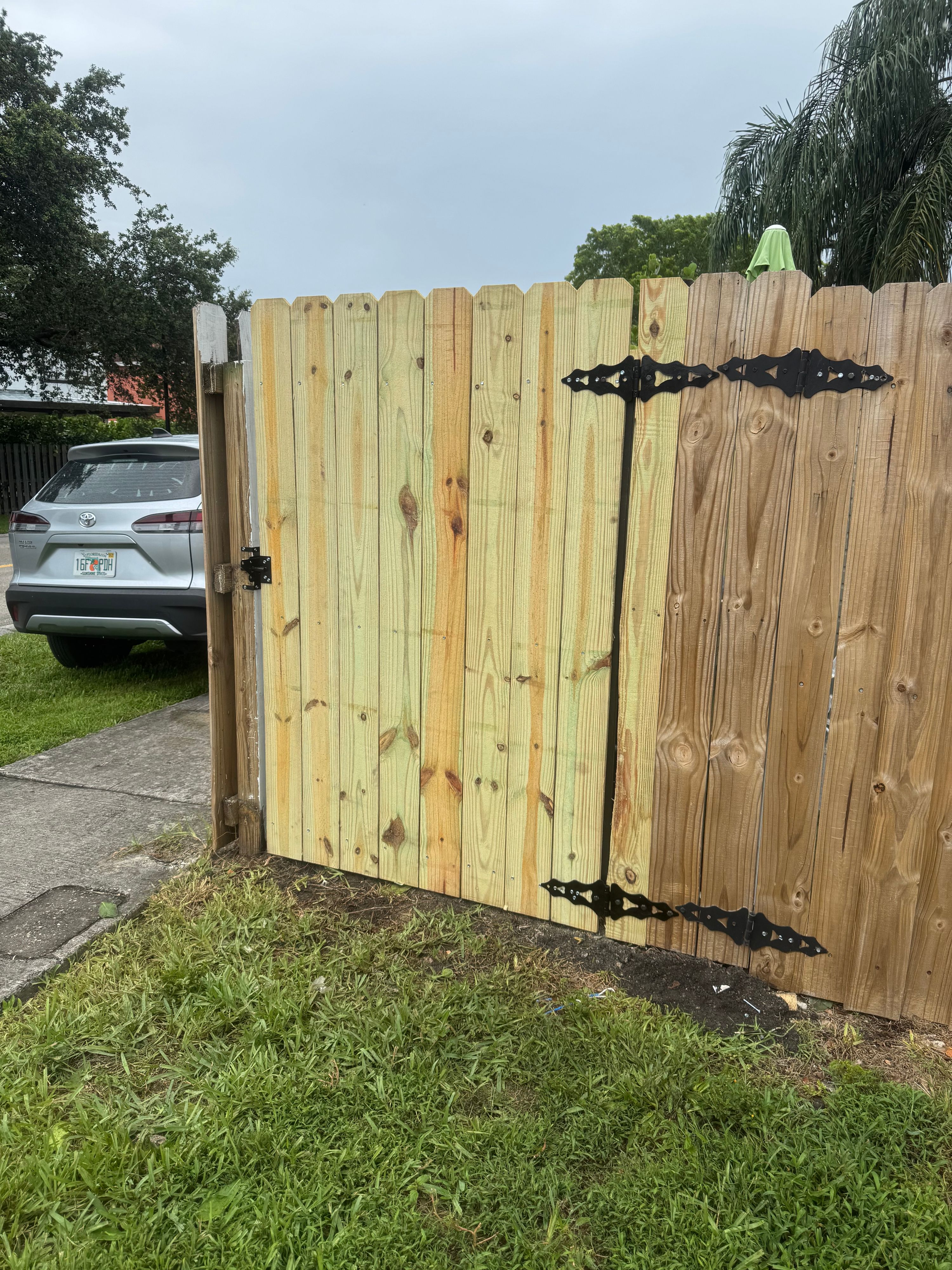 Pressure-treated wood fence gate with decorative strap hinges built by YGN Quality Multiservices