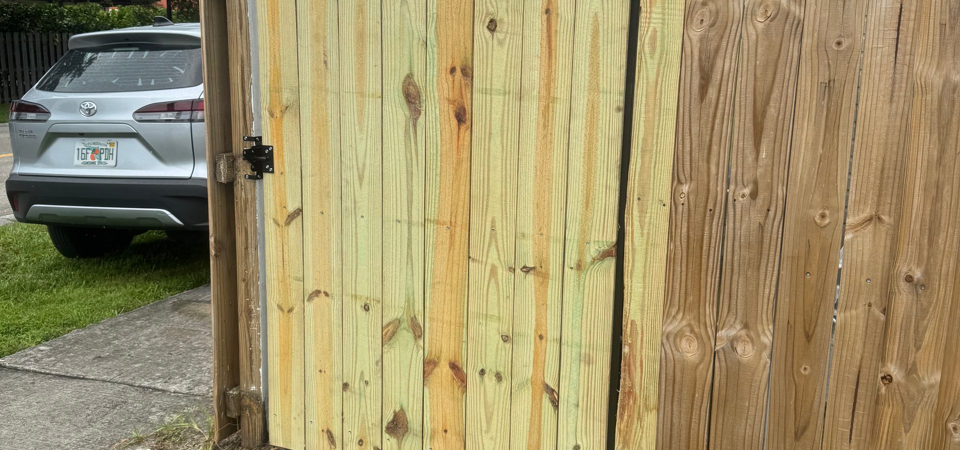 Pressure-treated wood fence gate with decorative strap hinges built by YGN Quality Multiservices